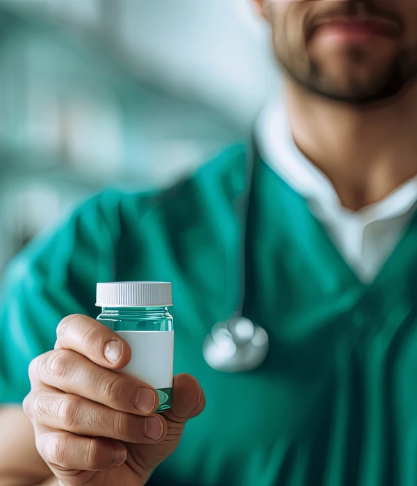 zorgprofessional in groene scrubs met pillenflesje